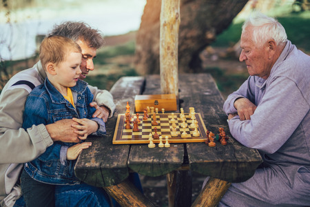 Active retired people, old friends and free time, two senior men having fun and playing chess at...