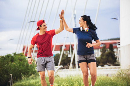 Happy couple running across the bridge. Healthy lifestyle.