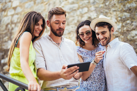 Group of young tourist friends with digital tablet having funの写真素材