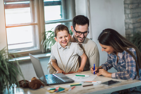 Smiling family drawing together at home, having funの写真素材