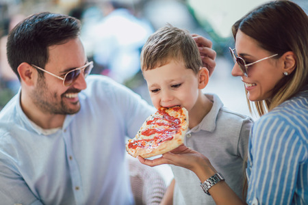 Portrait of happy family spending time in pizzeriaの写真素材