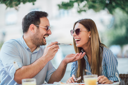 Couple eating pizza snack outdoors.They are sharing pizza and eating.の写真素材