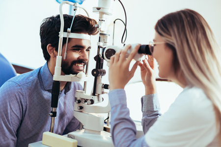 Optometrist checking patient eyesight and vision correctionの写真素材