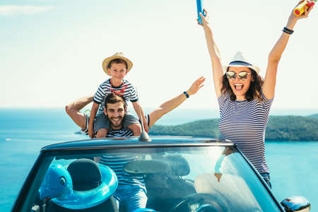 Happy family travel by car to the sea. People having fun in cabriolet. Summer vacation conceptの写真素材