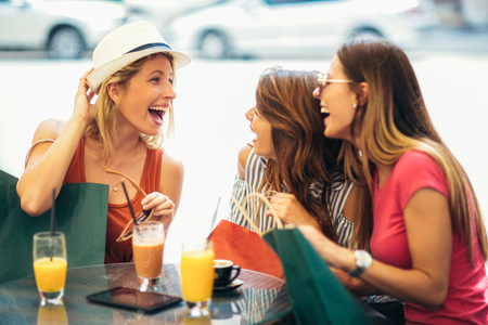 Three young women in a cafe after a shoppingの写真素材