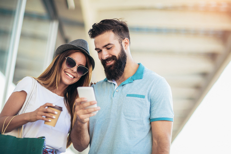 Beautiful couple enjoy shopping together, young couple holding shopping bagsの写真素材
