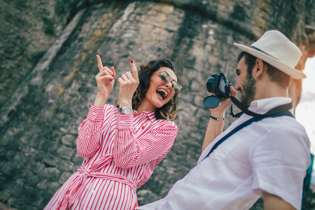 Tourist couple enjoying sightseeing and exploring city. Happy tourists taking photoの写真素材
