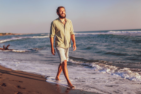 One man walking on the beach on sunset.の写真素材