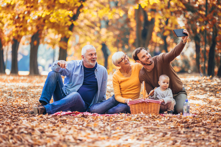 Multl generation family in autumn park having funの写真素材