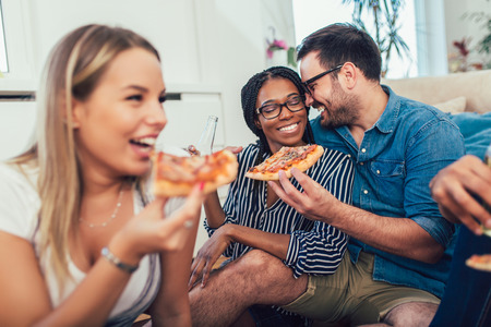 Group of young friends eating pizza.Home party.Fast food concept. Selective focusの写真素材