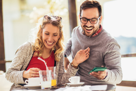 Beautiful loving couple sitting in a cafe enjoying in coffee and conversation. Love, romance, datingの写真素材