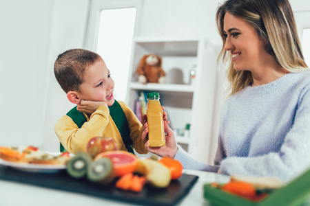 Mother making breakfast for her children in the morning and a snack for schoolの写真素材