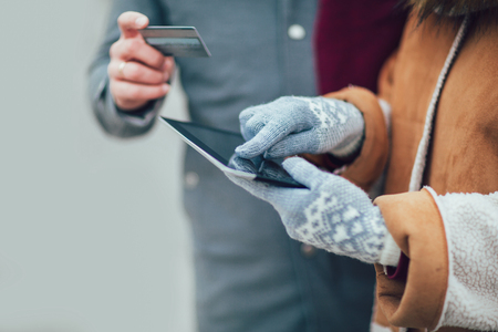 Young couple using a digital tablet for on line shopping, close up.の写真素材