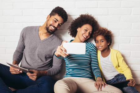 Cute african american family making a selfie together at home, selective focus.の写真素材