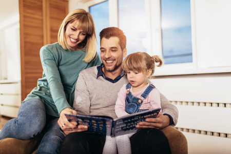 Happy family reading book at home, selective focus.の写真素材
