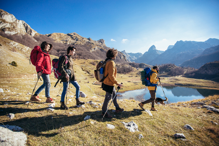 Group of hikers walking on a mountain at autumn dayの写真素材