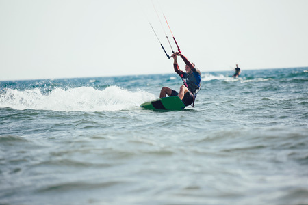Professional kiter makes the difficult trick on a beautiful background. Kitesurfing Kiteboarding...