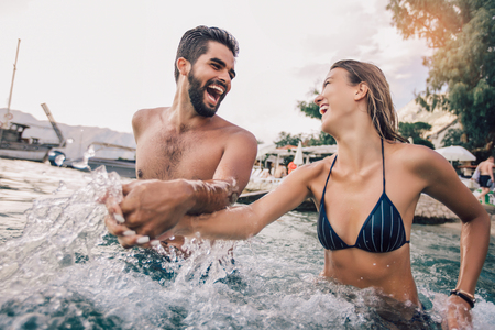 Sexy young loving couple on the beach having funの写真素材