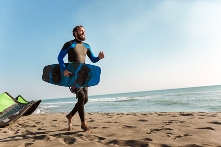 Portrait of surfer man with surf board on the beach. Summer sport activityの写真素材