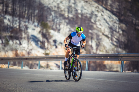 Man ride mountain bike on the road. Sport and active life concept.の写真素材