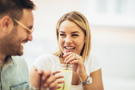 Beautiful loving couple sitting in a cafe having fun.の写真素材