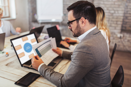 Business colleagues working on laptop in modern office.の写真素材
