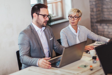 Business colleagues working on laptop in modern office.の写真素材