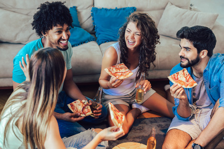 Group of young friends eating pizza.Home party.の写真素材