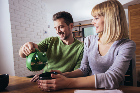 Couple talking in the night in the living room at home and drink teaの写真素材