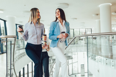 Group of businesswomen walking and taking stairs in an office buildingの写真素材