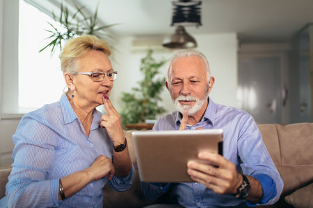 Smiling deaf senior couple talking using sign language on the digital tablet's camの写真素材