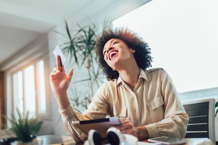 African american woman with digital tablet and credit card in home officeの写真素材