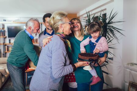 Grandmother and grandfather bring a gift for moving into a new apartment to their childrenの写真素材