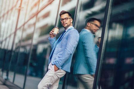 Portrait of a young happy businessman outside the office buildingの写真素材