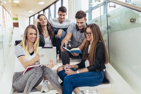 College life.Students are studying in library. Young people are spending time together. Reading book...