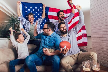 Happy friends or basketball fans watching basketball game on tv and celebrating victory at home.Friendship, sports and entertainment concept.の写真素材