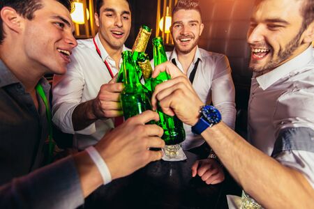 Group of young men toasting at a nightclubの写真素材