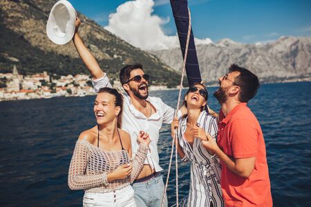 Smiling friends sailing on yacht. Vacation, travel, sea, friendship and people conceptの写真素材