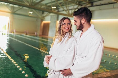 Happy young couple enjoying treatments and relaxing at wellness spa centerの写真素材