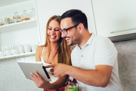 Young couple using digital tablet in the kitchenの写真素材