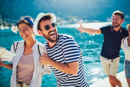 Happy group of tourists traveling and sightseeing together near the seaの写真素材