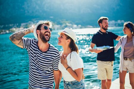 Happy group of tourists traveling and sightseeing together near the seaの写真素材