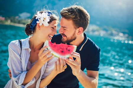 Cheerful couple holding slices of watermelonの写真素材