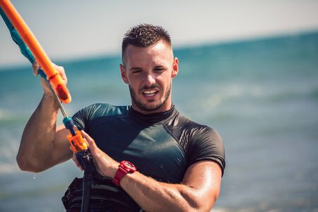 Kitesurfing. Man rides on kite on waves