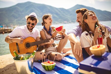 Young people having fun on summer vacation.Happy friends drinking tropical cocktails on the beach.の写真素材