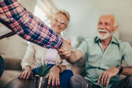 Positive aged couple consulting with insurance agentの写真素材