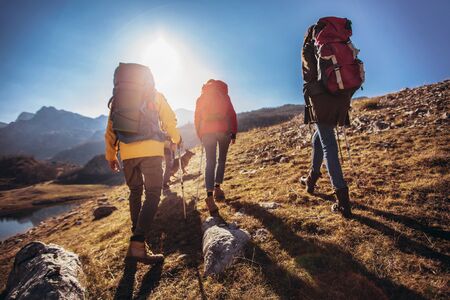 Group of hikers walking on a mountain at autumn day