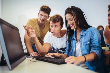 College students sitting in a classroom, using computers during class.