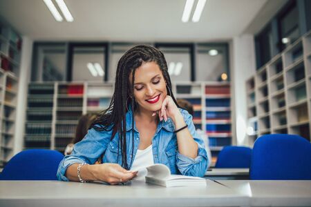 Portrait of a beautiful student in a libraryの写真素材