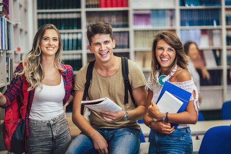 Group of college students at the library smilingの写真素材